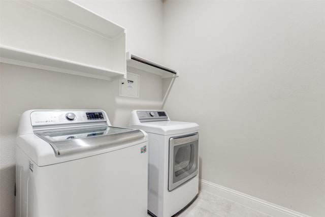 laundry room with light tile patterned floors, baseboards, laundry area, and washing machine and clothes dryer