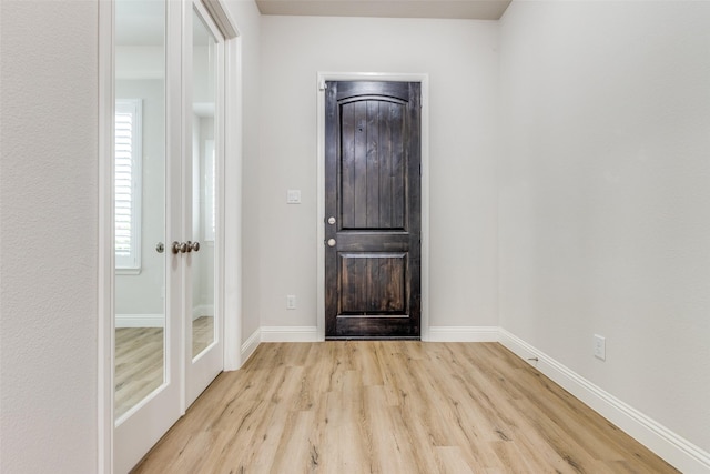foyer entrance with baseboards and wood finished floors