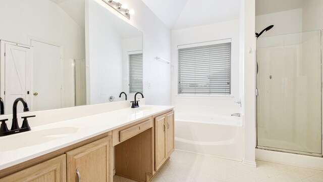 bathroom featuring double vanity, a sink, a bath, and a stall shower