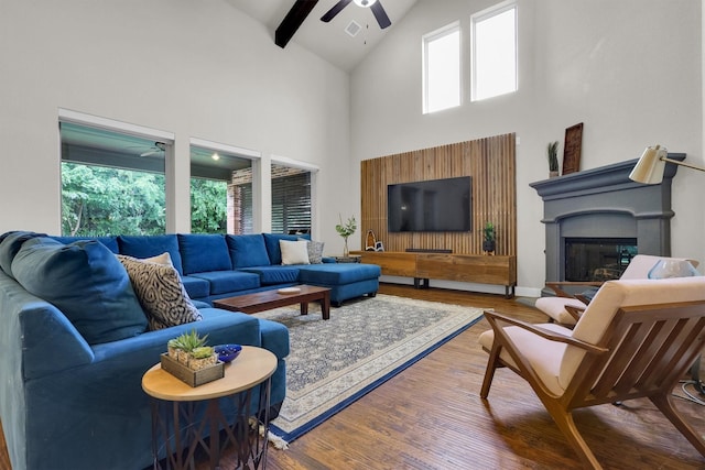 living room featuring plenty of natural light, a ceiling fan, wood finished floors, and high vaulted ceiling