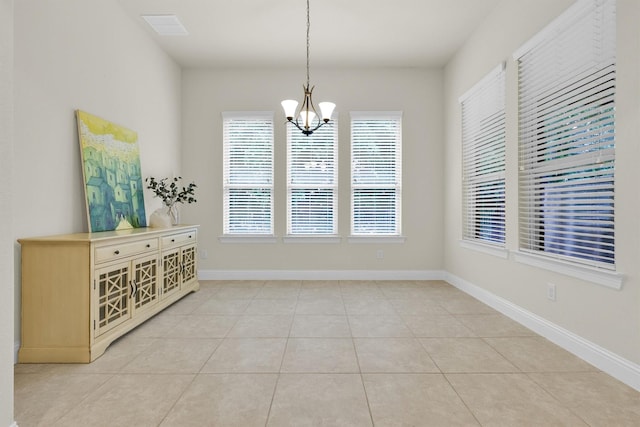 unfurnished dining area with an inviting chandelier, baseboards, light tile patterned flooring, and visible vents