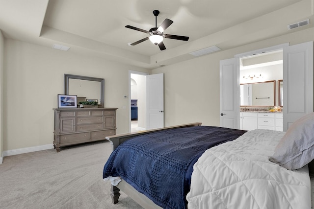 bedroom featuring visible vents, a raised ceiling, and light colored carpet