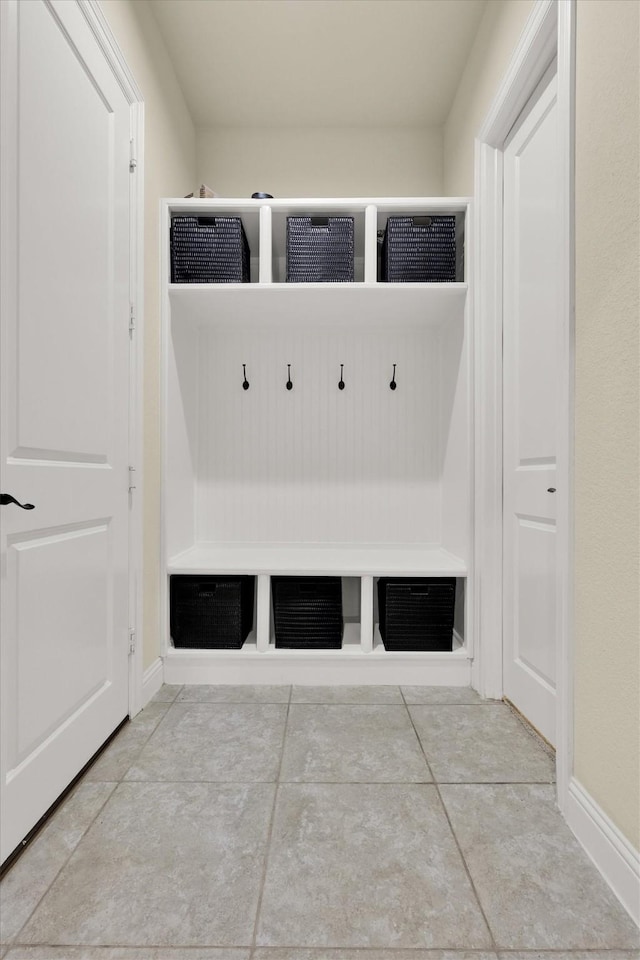 mudroom with baseboards and tile patterned floors