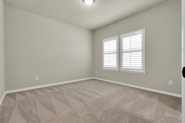 empty room featuring baseboards and carpet