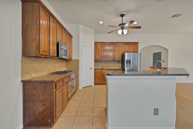 9405 National Pines Dr, Mckinney, TX 75072 - kitchen with ceiling fan, visible vents, appliances with stainless steel finishes, brown cabinets, and light tile patterned floors