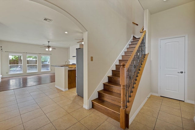 9405 National Pines Dr, Mckinney, TX 75072 - stairs with visible vents, tile patterned flooring, baseboards, ceiling fan, and arched walkways