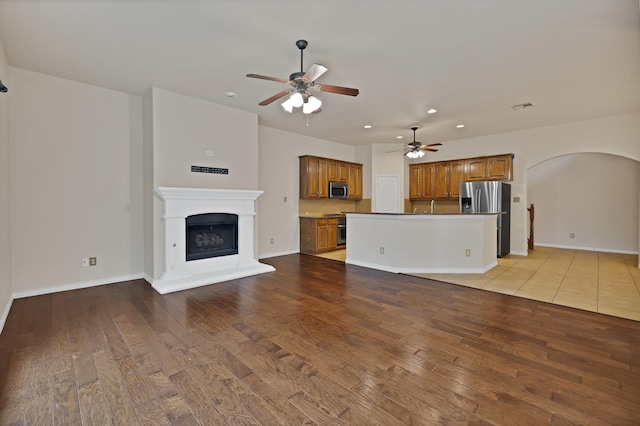 9405 National Pines Dr, Mckinney, TX 75072 - unfurnished living room featuring recessed lighting, a ceiling fan, arched walkways, and hardwood / wood-style flooring