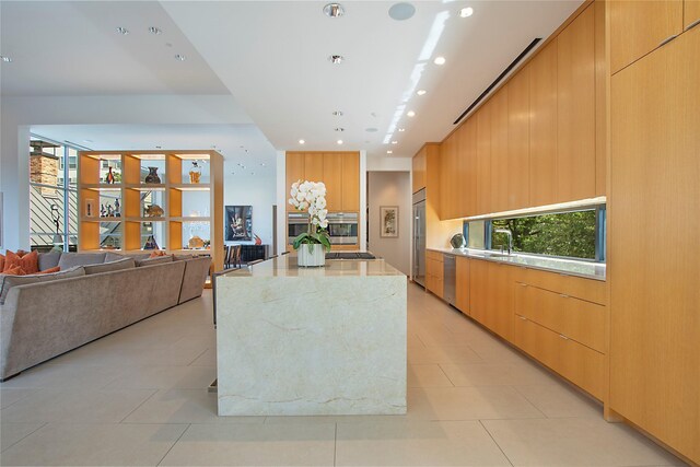 kitchen with appliances with stainless steel finishes, open floor plan, modern cabinets, and a kitchen island
