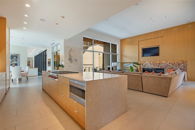 kitchen with light tile patterned flooring, modern cabinets, appliances with stainless steel finishes, and open floor plan