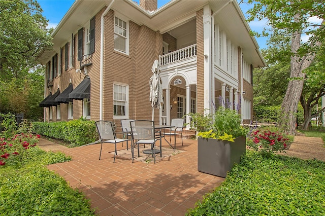 view of patio featuring outdoor dining space and a balcony