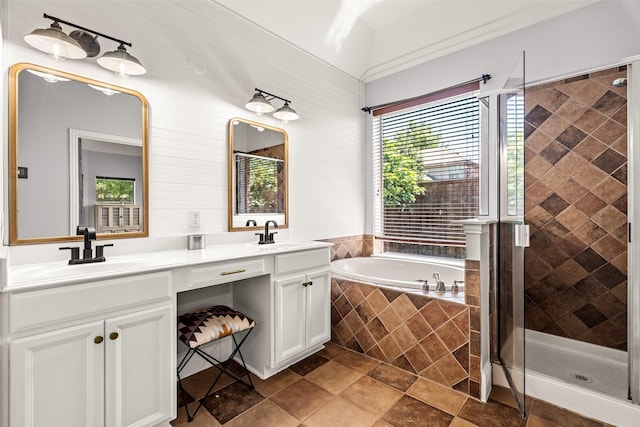 bathroom with a bath, double vanity, a sink, and a stall shower
