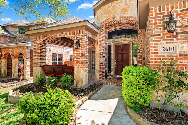 view of exterior entry with brick siding