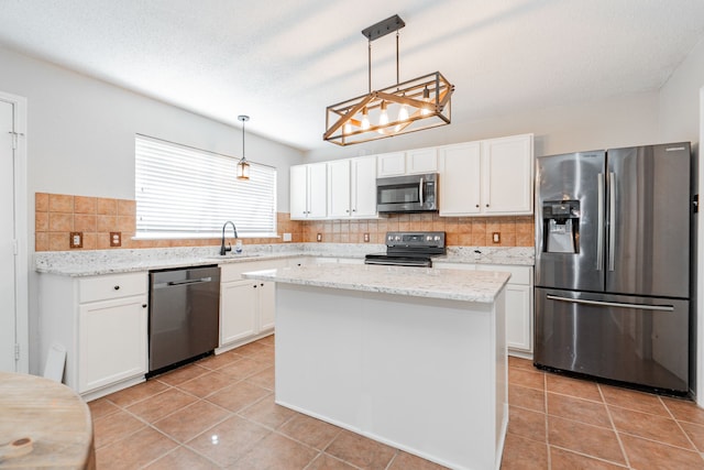 kitchen featuring a sink, stainless steel appliances, light tile patterned floors, tasteful backsplash, and white cabinetry