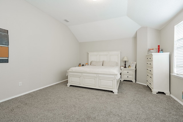 carpeted bedroom with visible vents, vaulted ceiling, and baseboards