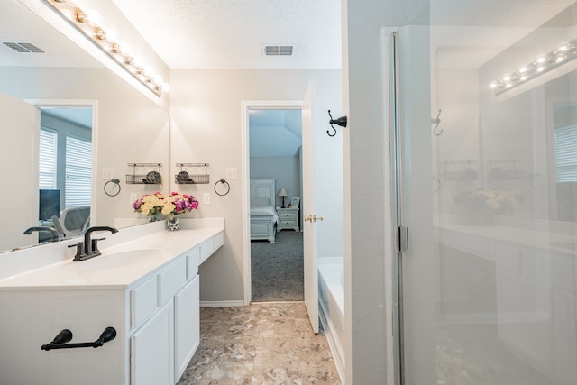 ensuite bathroom with visible vents, connected bathroom, an enclosed shower, and vanity