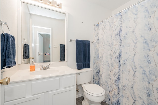 bathroom featuring a shower with shower curtain, toilet, and vanity