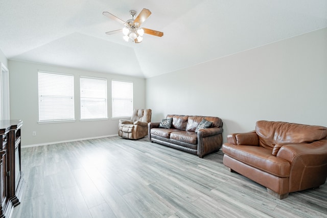 living area featuring a ceiling fan, baseboards, lofted ceiling, and light wood-type flooring