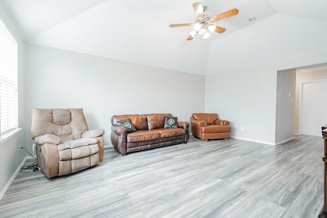 living area featuring light wood-type flooring, a ceiling fan, and a healthy amount of sunlight