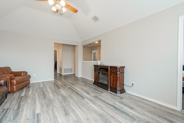 unfurnished living room with a ceiling fan, visible vents, vaulted ceiling, and light wood-style floors