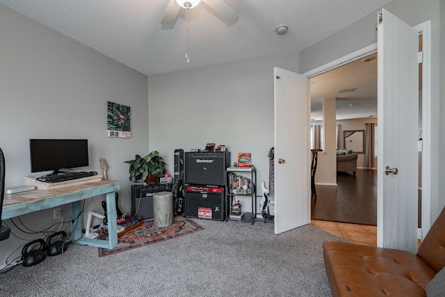 carpeted office featuring a textured ceiling, ceiling fan, and tile patterned flooring