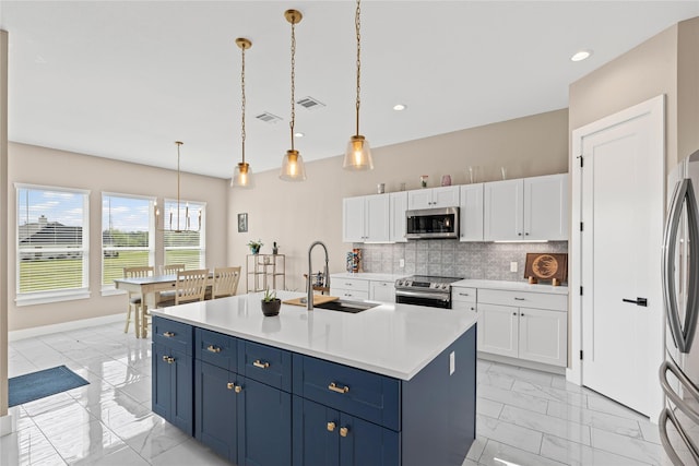 kitchen with a sink, stainless steel appliances, marble finish floor, white cabinets, and blue cabinets