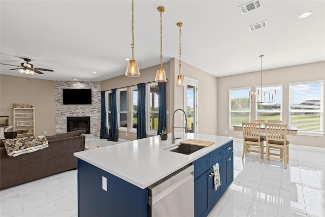 kitchen featuring blue cabinets, marble finish floor, dishwasher, a sink, and visible vents