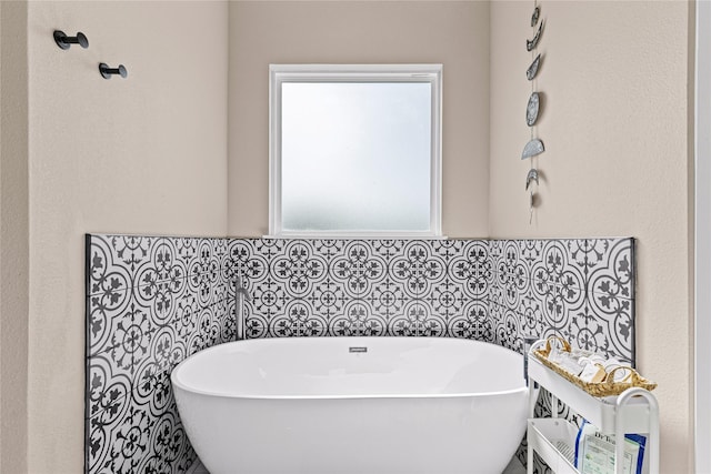 bathroom featuring tile walls and a freestanding bath