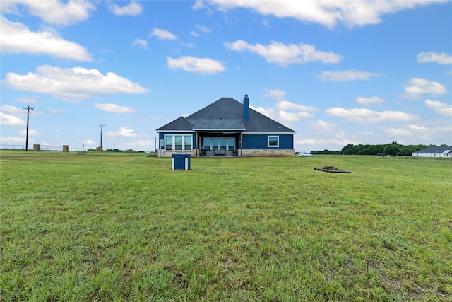 rear view of property with a lawn and a chimney