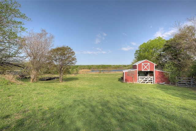 view of yard featuring fence, a barn, and an outbuilding