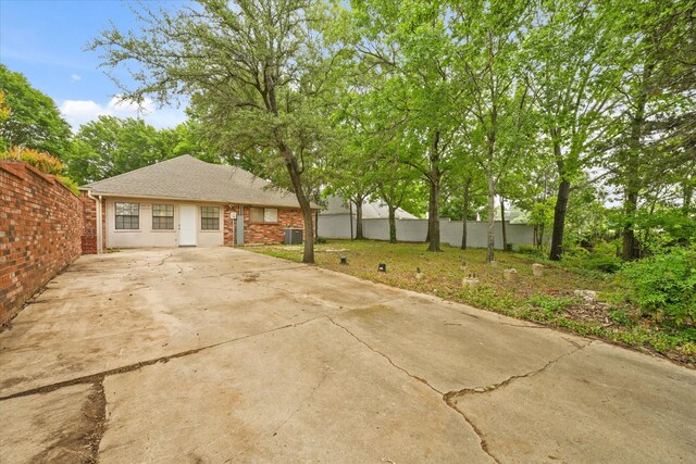 view of patio featuring fence and concrete driveway