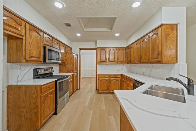 kitchen with visible vents, a sink, brown cabinets, and stainless steel appliances