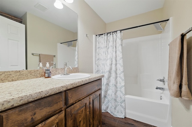 bathroom featuring visible vents, shower / tub combo, wood finished floors, and vanity