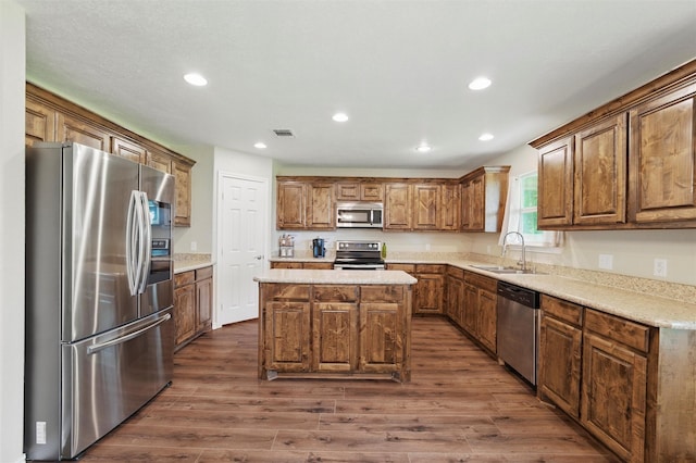 kitchen with recessed lighting, a sink, appliances with stainless steel finishes, and dark wood finished floors