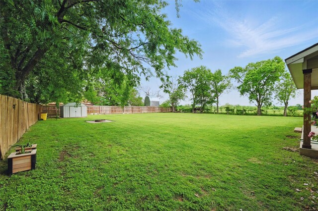view of yard with a storage shed, an outdoor structure, and a fenced backyard