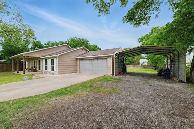 view of front of home featuring a front lawn, driveway, a detached carport, and fence