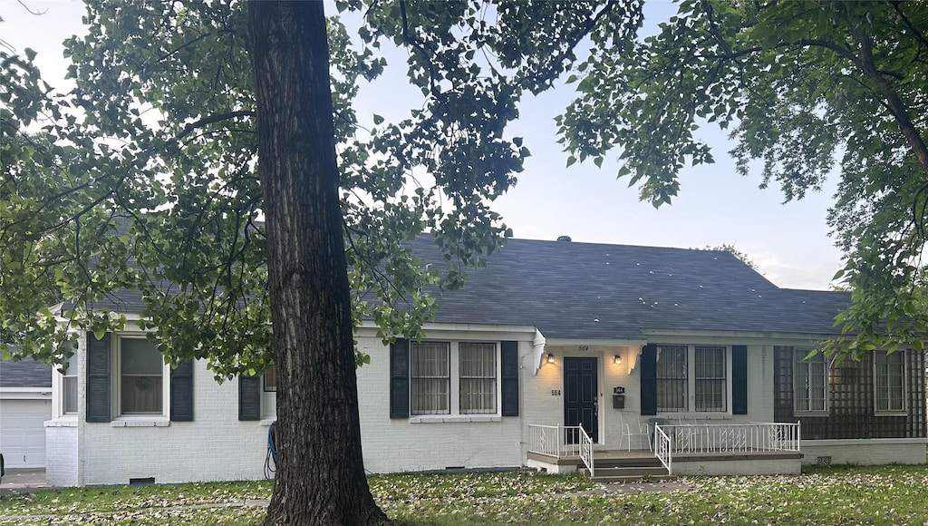ranch-style house featuring brick siding, crawl space, roof with shingles, and a garage
