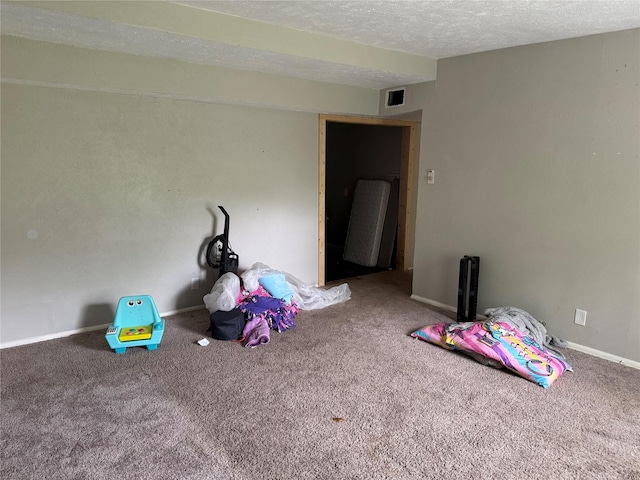 recreation room featuring carpet, visible vents, a textured ceiling, and baseboards