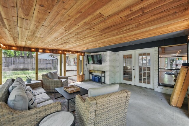 living area featuring visible vents, wood finished floors, ceiling fan, wooden walls, and lofted ceiling with beams