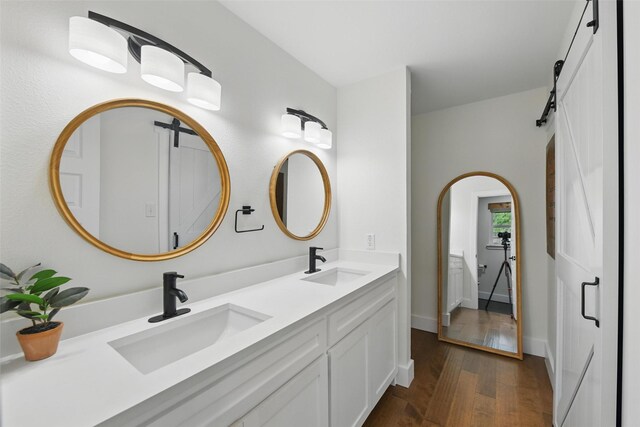 bathroom with a sink, toilet, double vanity, and wood finished floors