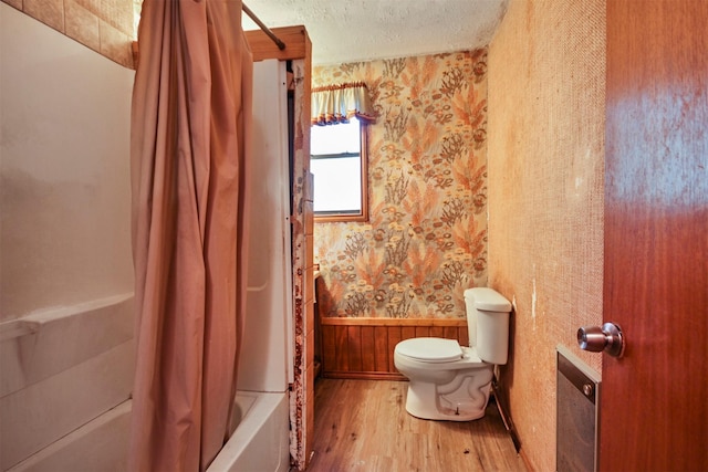 3412 Tin Top Rd, Weatherford, TX 76087 - full bathroom with wood finished floors, wallpapered walls, toilet, wainscoting, and shower / bathtub combination with curtain