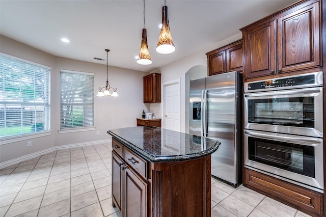4465 Mira Vista Dr, Frisco, TX 75034 - kitchen with stainless steel appliances, light tile patterned floors, dark stone countertops, a kitchen island, and recessed lighting