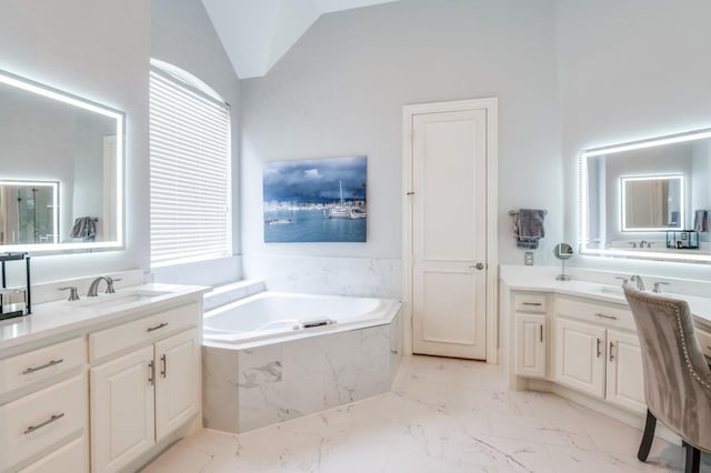 bathroom featuring marble finish floor, lofted ceiling, a healthy amount of sunlight, a bath, and a sink