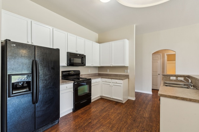 kitchen featuring white cabinetry, a sink, arched walkways, black appliances, and dark wood-style flooring