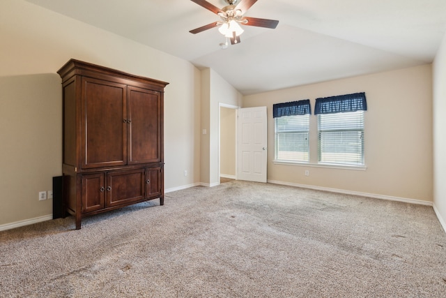 unfurnished bedroom with a ceiling fan, vaulted ceiling, light carpet, and baseboards