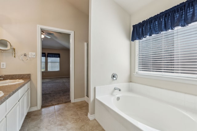 full bath with tile patterned floors, vanity, baseboards, a ceiling fan, and a garden tub