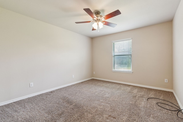 carpeted empty room featuring ceiling fan and baseboards