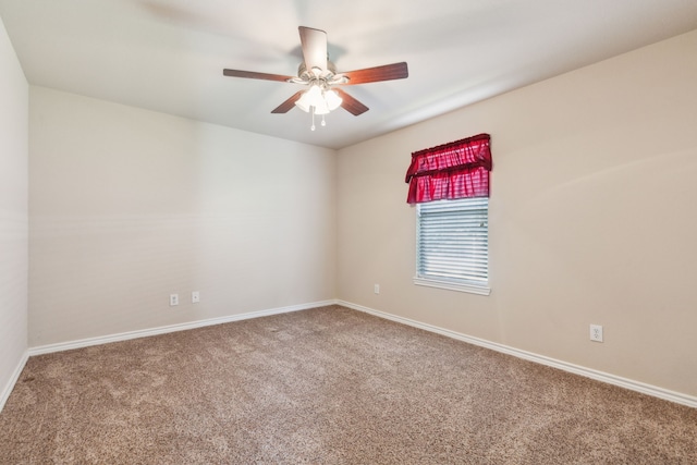 carpeted spare room with baseboards and a ceiling fan