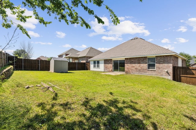 back of house with a yard, a storage unit, a fenced backyard, and brick siding
