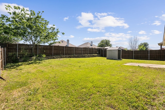 view of yard featuring a fenced backyard, an outbuilding, and a storage shed