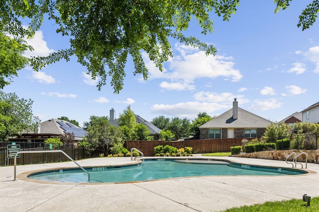 community pool with fence and a patio
